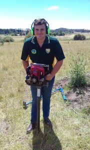 Dominic jones smiling whilst operating out portable coring rig in Armidale