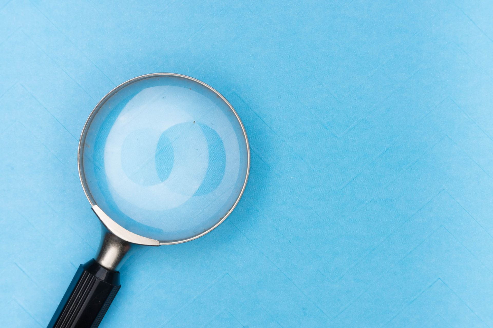 Stock image of a magnifying glass on a light blue background
