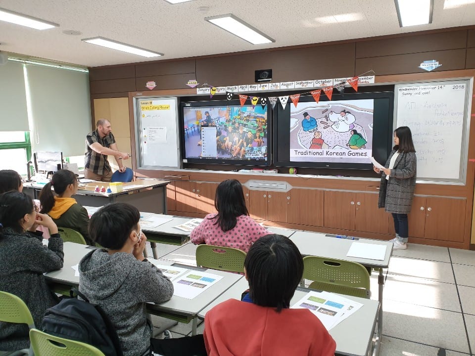 A classroom of students in South Korea watching a video screen with live footage streamed from a classroom of students in Australia
