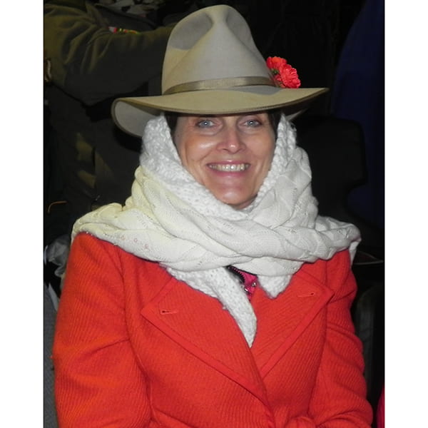 Informal image of Margaret Strike in red coat, slouch hat and Poppy for Anzac Day at Gallipoli