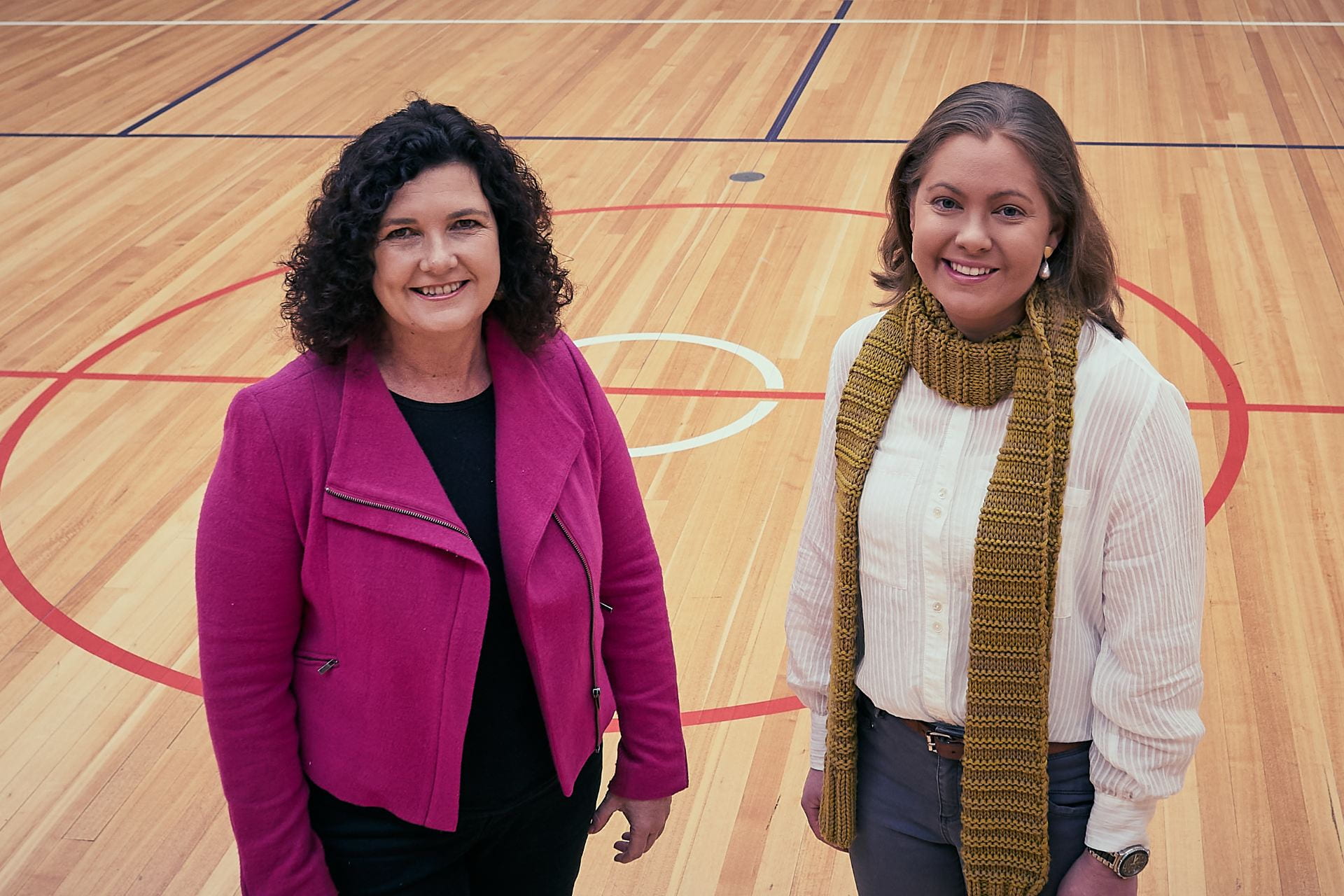 Aerial image of UNE education researchers Associate Professor Pep Serow and Dr Kristy O'Neill on the indoor UNE basketball courts