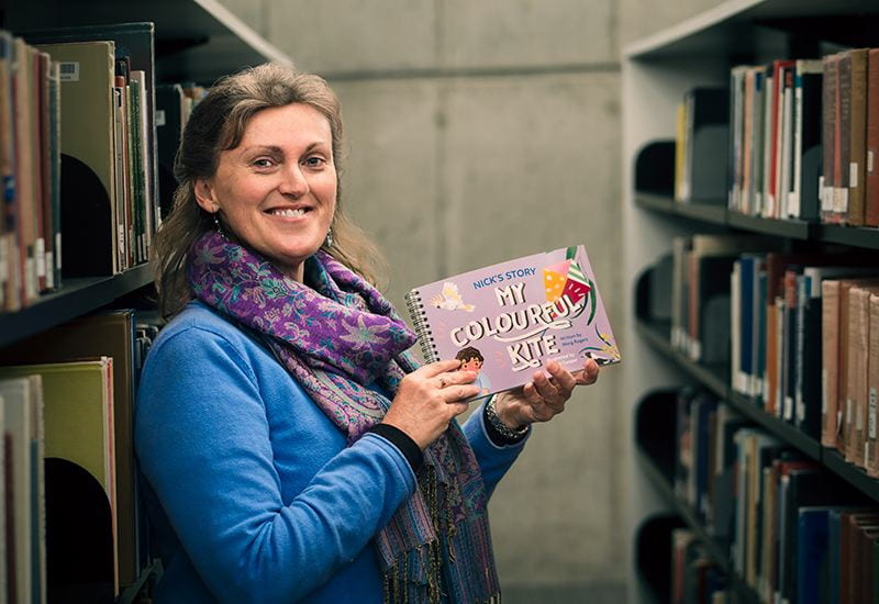 Dr Marg Rogers, UNE Early Childhood Lecturer with one in a series of storybooks she has authored for children in defence families that has been awarded aCouncil of Humanities, Arts and Social Sciences awards for Distinctive Work for 2022