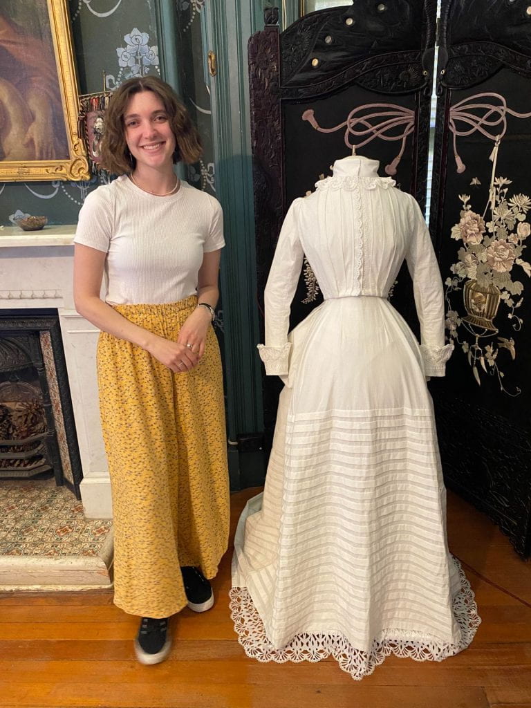 Young Honours student Kirby Moore with her project, a reconstruction of an 1884 wedding gown.