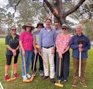 Members of the School of Education STEM team pose on lawn with croquet mallets.