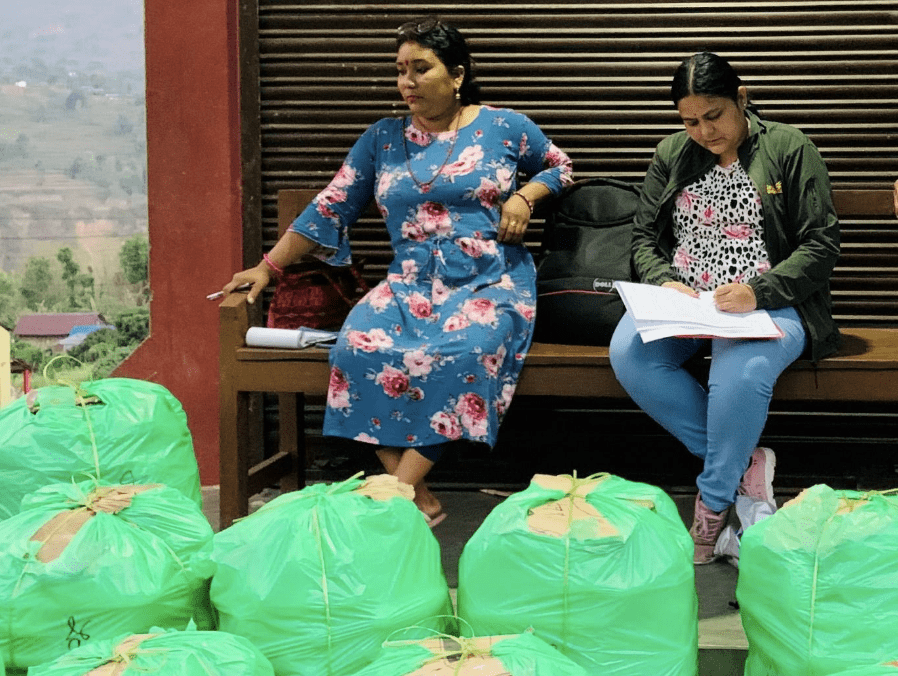Deepa speaks with a female farmer as she waits to transport her vegetables.