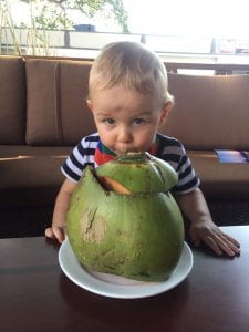 Erin's son Will drinking a coconut in East Timor 