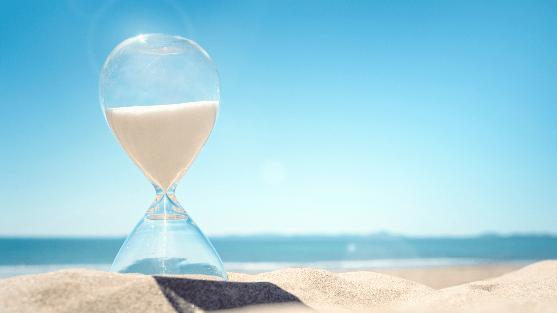 Hourglass on a sunny beach