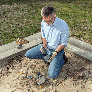 Mark Moore examines stone artefacts in a knapping pit